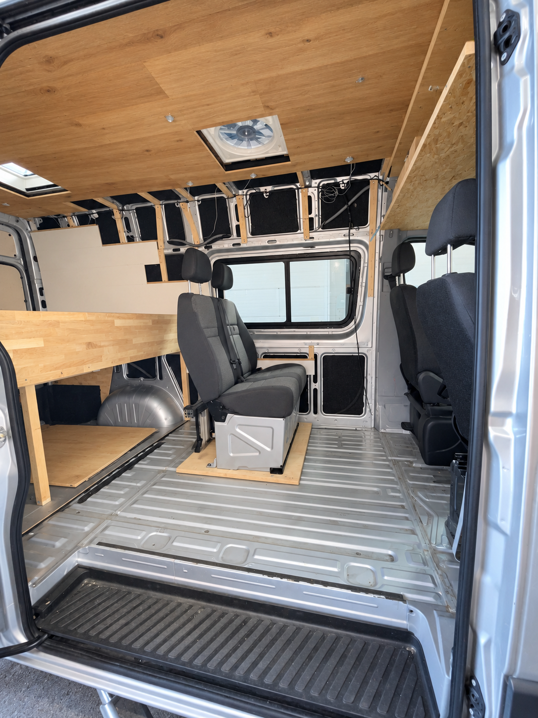 Beifahrer-Sitzbank auf Bodenplatte im Kastenwagen, Blick durch die Schiebetür