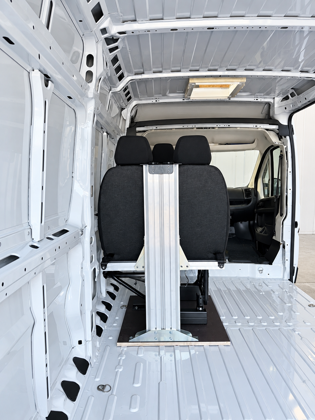 Beifahrer-Sitzbank von hinten mit Gurtbock-Säule aus Aluminium im leeren Kastenwagen
