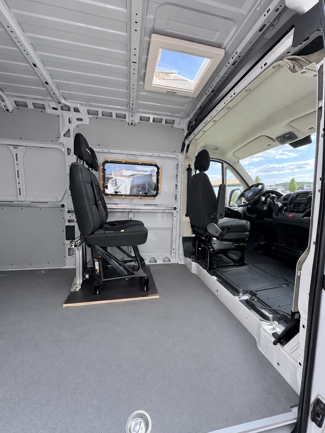 Beifahrer-Sitzbank mit Gurtbock im Wohnraum eines Fiat Ducato, Blick zum Fahrerhaus