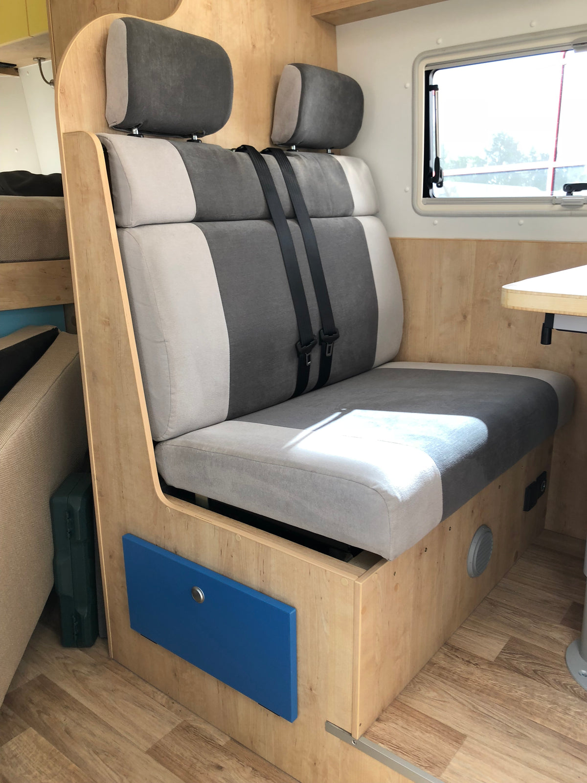 Relaxo Sitzbank mit zweifarbigem Polster, Kopfstützen und 3-Punkt-Gurten in Holz-Sitztruhe im Wohnmobil